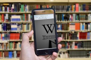 "SABER Y GANAR", PARADIGMA DE UN MODELO EDUCATIVO. 1 Un móvil recoge el modelo educativo del saber enciclopédico con una estantería llena de libros, y obtiene la imagen de la Wikipedia.